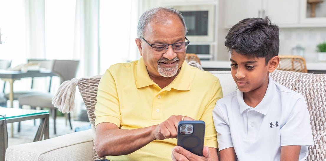 Photo of father and son using a mobile phone to e-checkin for an appointment